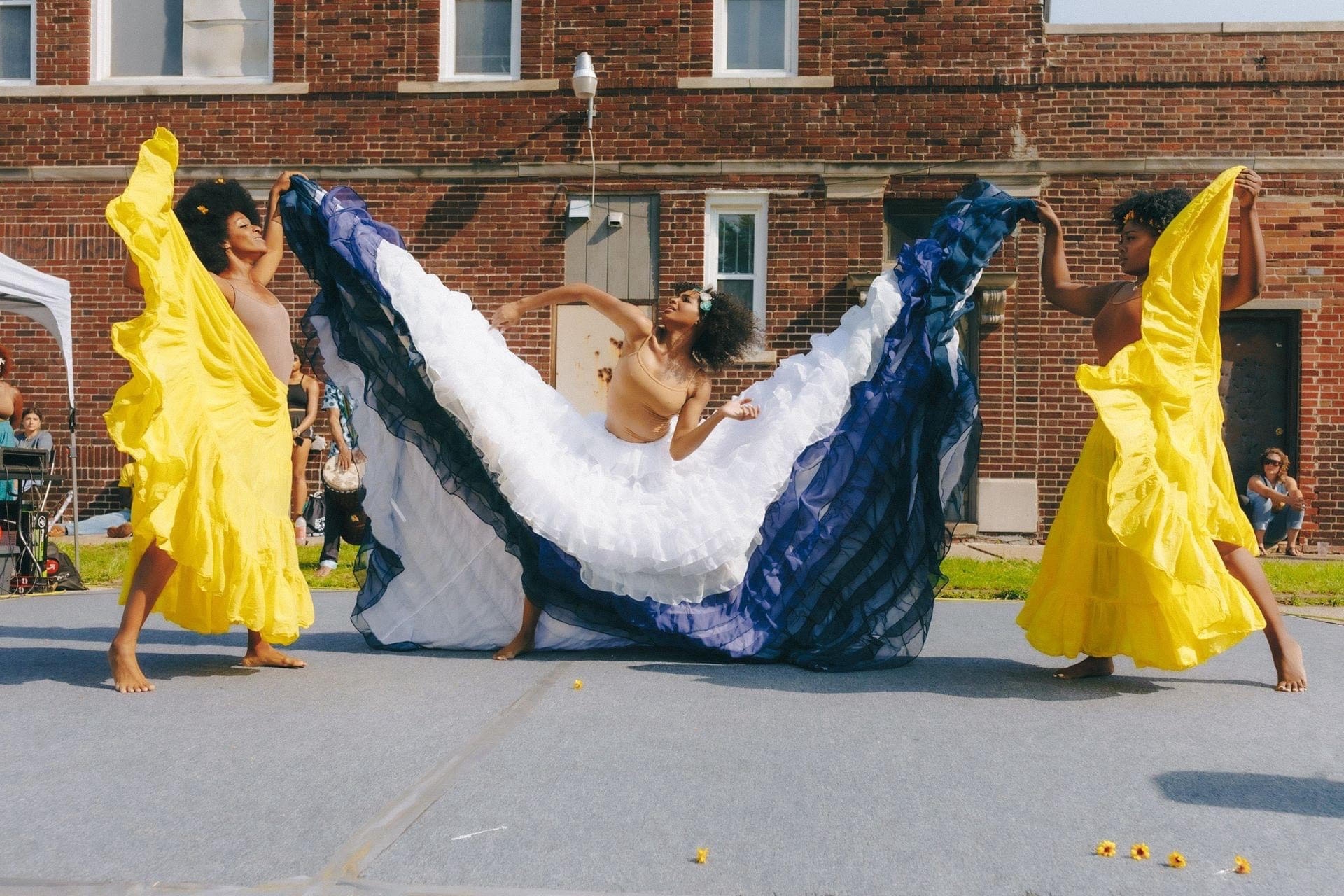 Students dance in colorful dresses on campus