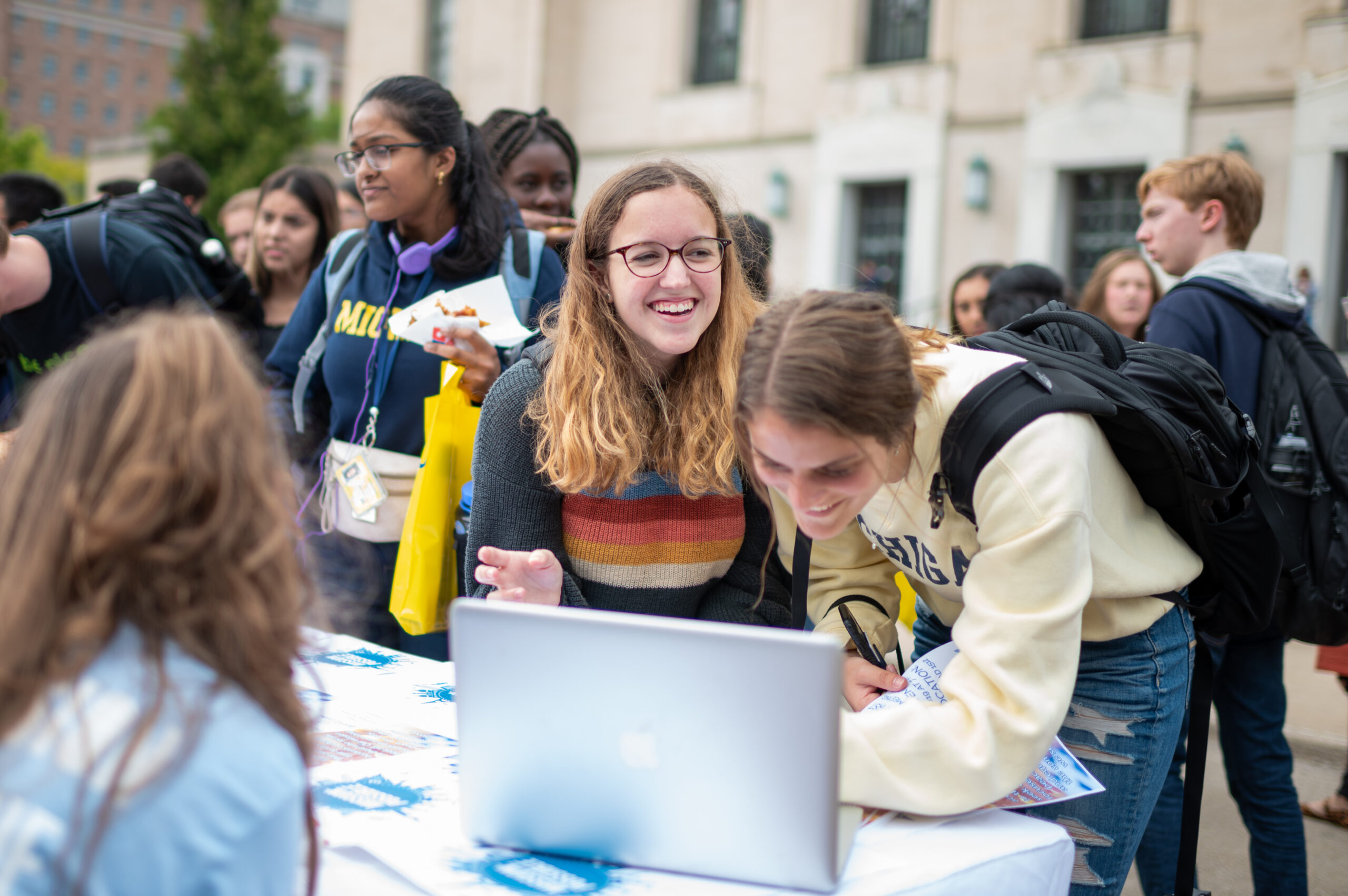 Students gather around table during campus event