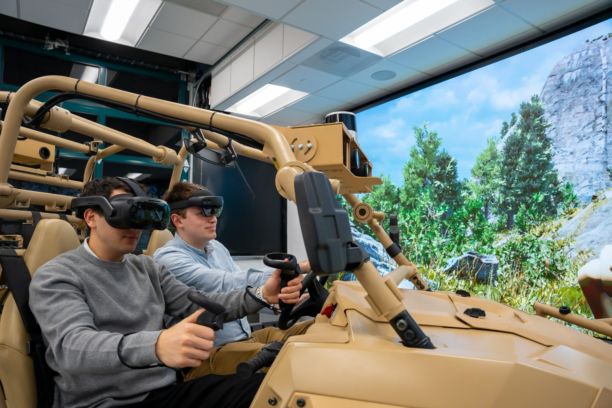 Two students sit in vehicle simulator