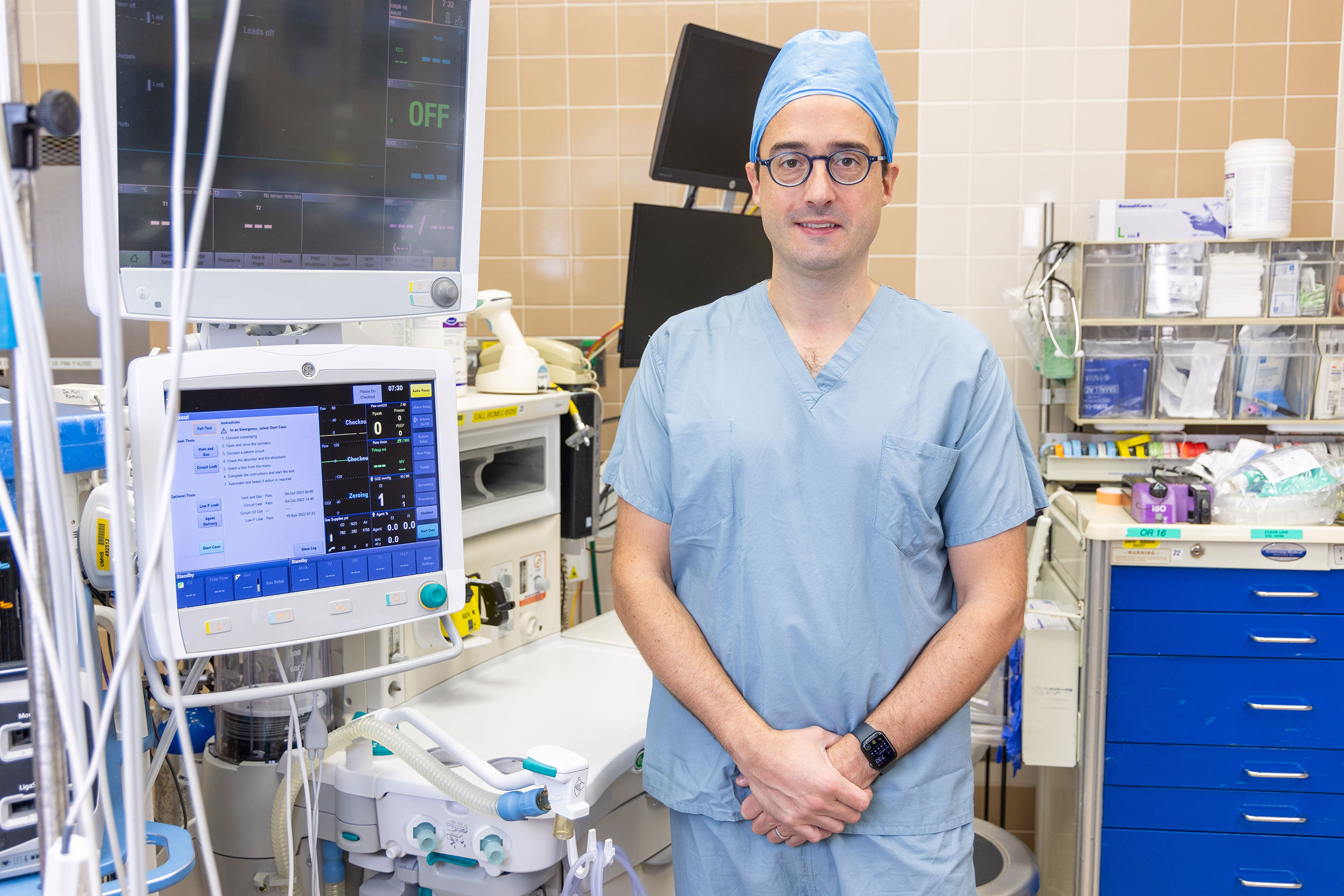 David Hovord, assistant professor of anesthesiology and one of the project leads for the Green Anesthesia Initiative, is shown in an operating room with an anesthesia machine in the background.