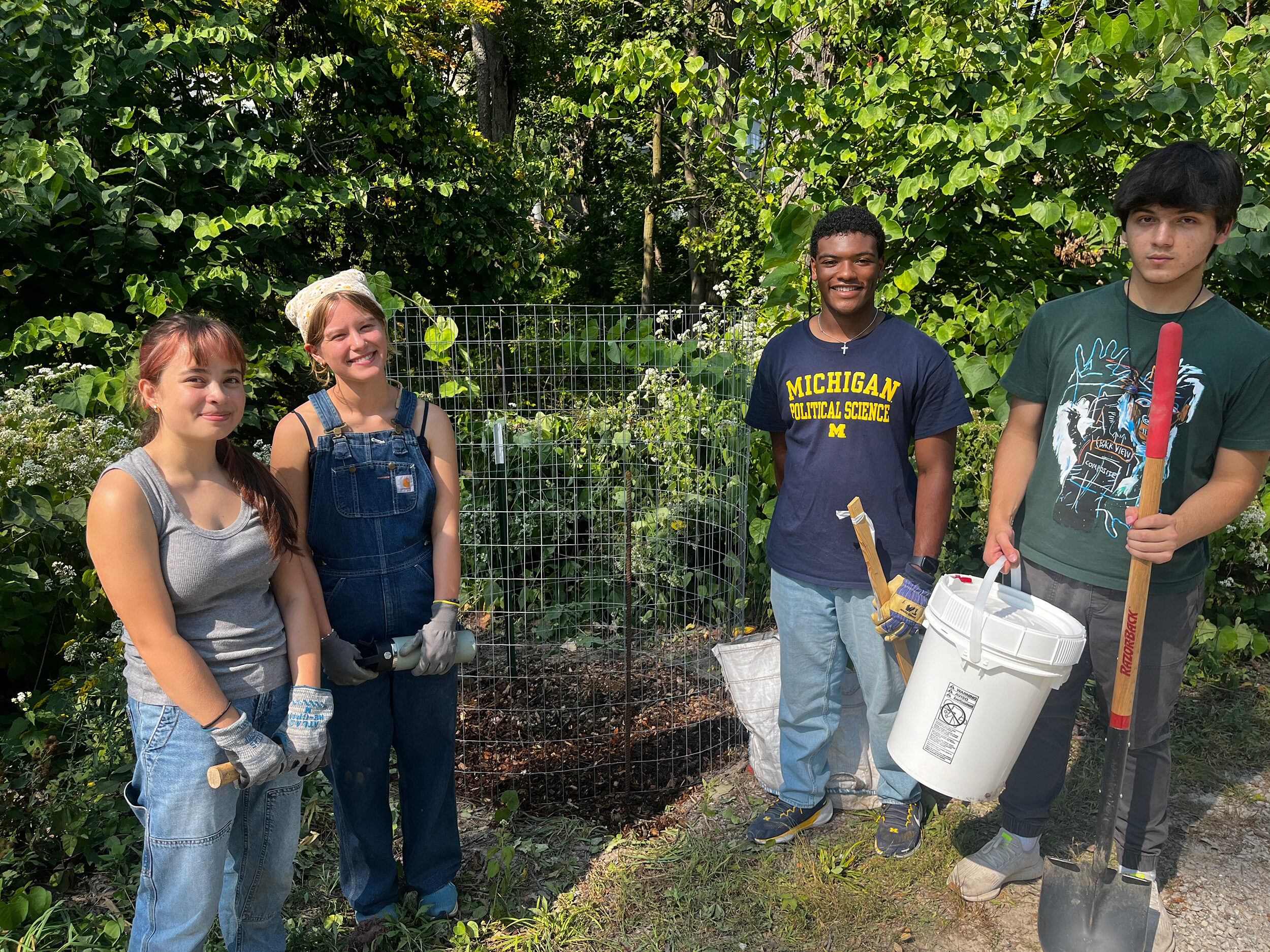 Students work on a campus tree lifecycle project in Nichols Arboretum, planting trees to replace those damaged by storms and which were sawn into lumber for class projects.